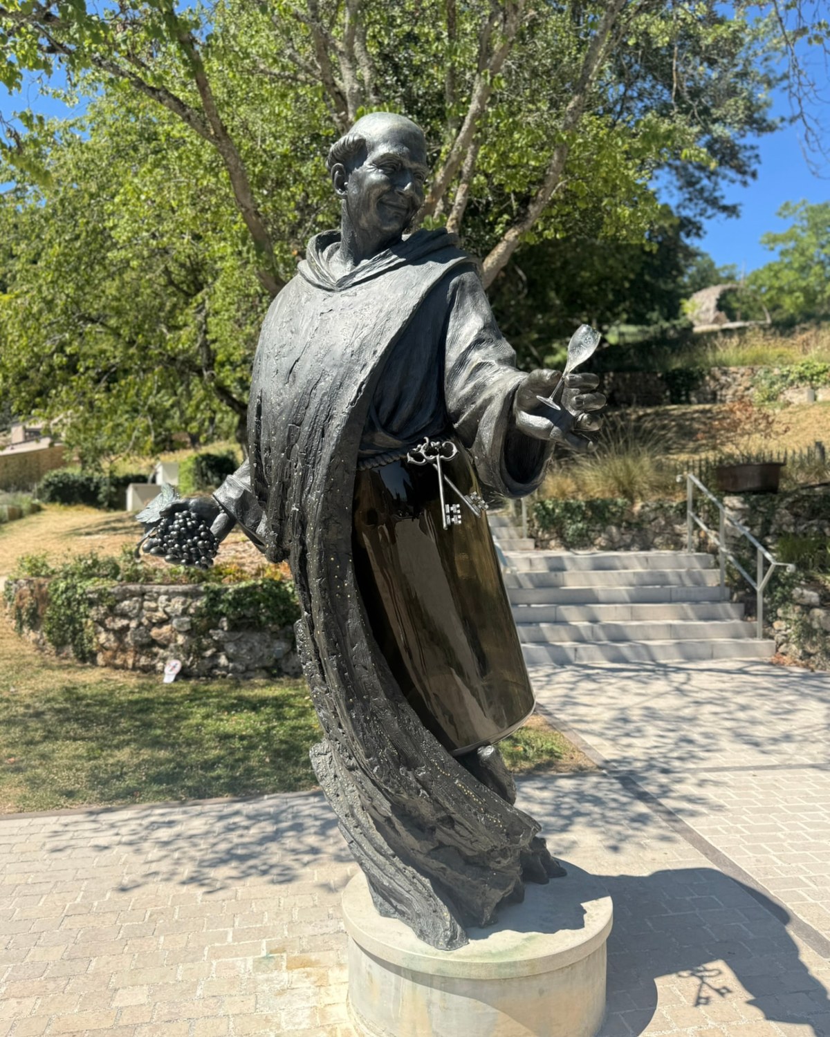 Bronzestatue af Dom Pérignon med champagneflaske og glas i Hautvillers